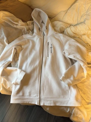 Vit sailracing kofta  - .Säljer en helt ny sailracing kofta från kidsbrandstore kunde inte lämna tillbaka den pågrund av att min brorsa tog av prislappen och slängde den och den va för liten på mig. Storlek 170 cm
