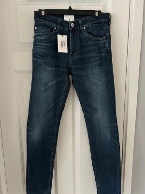 Tiger of sweden mörkblå jeans med snygg tvätt  W30 L34 - Snygga jeans i mörkblå tvätt med klassisk femficksdesign och är slimfit. Jeansen har en modern passform och är tillverkade i slitstark bomull med lite stretch för extra komfort. Perfekta till vardagslooken.
