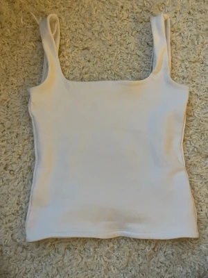 Vit ribbad linnetopp från Zara🧡🪽 - Säljer en enkel och stilren vit ribbad linnetopp från Zara. Toppen har breda axelband och rak skärning. Materialet är mjukt och stretchigt för en bekväm passform🩵🧡