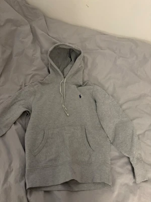 Grå Ralph lauren hoodie - Säljer min hoodie från Ralph lauren då den inte passar mig längre. Den är bra använd utan några defekter. Den har normal passform