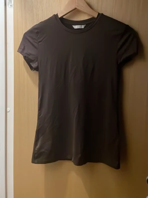 brun tajt h&m😍 - En superfin tajt T-shirt från h&m, hittar tyvärr inte storleken men den passar mig och jag brukar oftast s. Inga defekter eller liknande (köptes i somras men nästan aldrig använd) skriv privat för fler frågor❤️