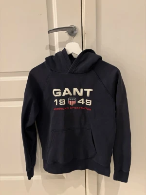 Mörkblå Gant hoodie - Tja. Säljer denna mörkblå Gant hoodien i bra skick. Den är i storlek 13-14.