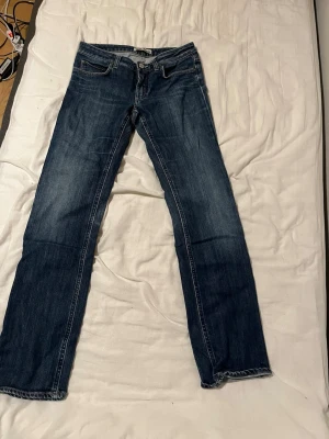 Blå raka jeans från Acne Jeans - Vet inte exakta storleken men den passar som 30/31 på nudie jeans, skriv ett meddelande för mått! Snygga blå jeans från Acne Jeans med klassisk femficksmodell och raka ben. Jeansen har en mörk tvätt med subtila slitningar och är tillverkade i robust denim. Perfekta för dig som gillar en enkel och tidlös stil.