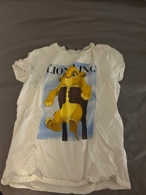 Vit Lion King t-shirt från FB Sister - Vit t-shirt från new Yorker med tryck av Simba från Lejonkungen på framsidan. Älskar den men tyvärr blivit för liten