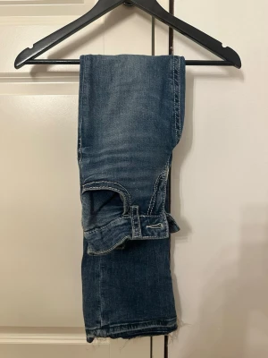 Blå jeans med broderad bakficka - Skitsnygga och coola jeans ifrån Ginayoung. Storlek 158= xxs/xs. Går att justera midjan med hjälp av resorband. Köptes för inte alls länge sen, därav inga defekter eller liknande. 