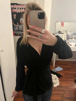 Svart omlottblus med knytband - Jätte fin blus från vila. Knappt använd priset kan diskuteras❣️