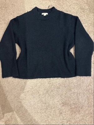 Svart stickad tröja med boxy passform - Mysig marinblå stickad tröja med rund hals och bred ribbstickad kant vid ärmslut och nederkant. 