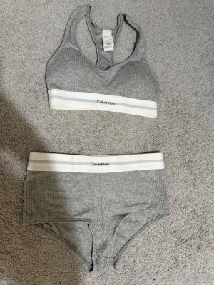 Calvin klein - Ett Calvin Klein sett. En bralette bh och boyshorts som de heter på hemsidan. Perfekt för att använda hemma som chill set eller under jeans och en tröja. Ett loungewear sett. Använda enbart 3-4 gånger så i mycket bra skick. Båda i storlek xs. Köpta för 622kr tillsammans. Mitt pris 350kr. Pris diskuteras vid snabb affär!