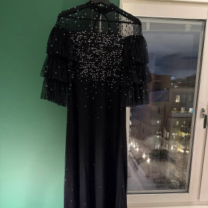 Svart långklänning med paljetter - Paljettklänning från Maya deluxe, storlek 34 men oversize. Mycket fint skick, använd endast två gånger. Möjligtvis någon enstaka paljett som lossnat men inget som syns eller stör. Kan hämtas på Södermalm alt skickas.