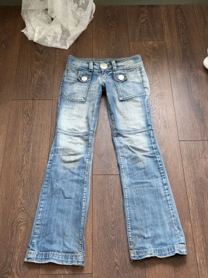 lågmidjade jeans - Snygga low waist / lågmidjade, utsvängda / bootcut jeans från P&Y vintage. Många detaljer, knappar och fickor. Storlek 28/32 ! 