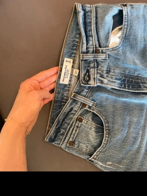 Women's Curve Love Ultra High Rise 90sStraight Jean - Klassiska blå  jeans med rak passform och normal midja. Jeansen är tillverkade i slitstarkt bomullsdenim och har den ikoniska femficksdesignen samt knappgylf. Perfekta för en avslappnad och tidlös stil.