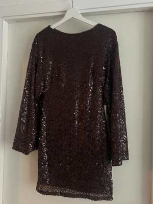 Brun festklänning  - Brun glittrig paljettklänning från Nelly, helt ny och otroligt fin ✨ Perfekt för festliga tillfällen.