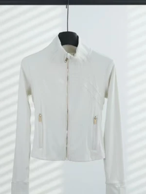 Vit croppad jacka med dragkedja - Stilren vit croppad jacka med hög krage och hel dragkedja framtill. Jackan har långa ärmar och två fickor med dragkedja. Perfekt för dig som gillar minimalistisk och sportig stil.
