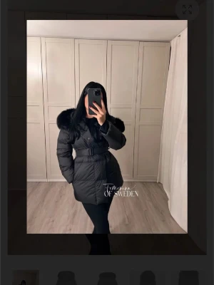 Svart dunjacka från Femme of Sweden - Snygg svart dunjacka från Femme of Sweden. Jackan har bälte i midjan för en markerad siluett och quiltad design. Perfekt för kalla vinterdagar och ger en lyxig känsla.