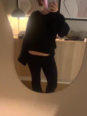 Svart croppad stickad  - Mysig svart stickad tröja med croppad passform och långa ärmar. Perfekt till höstens och vinterns outfits. Tröjan har en enkel design med rund hals och mjukt material.