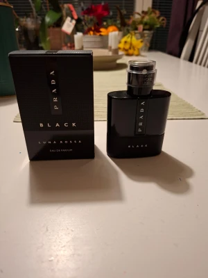 Prada Luna Rossa Black EdP - Prada Luna Rossa Black Eau de Parfum är en elegant parfym i en svart, stilren flaska med metallisk silverdetalj. Doften är modern och intensiv, perfekt för dig som gillar exklusiva och djupa doftnoter. Kommer i originalförpackning.