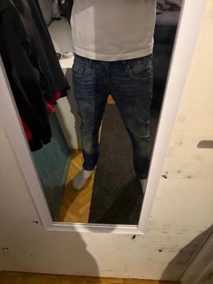 Lee blå jeans slim fit - Säljer ett par Lee blå jeans med slim passform. Klassisk femficksmodell med normal midja och raka ben. Jeansen är i ett mjukt bomullsmaterial och har snygg tvättad look med lätt slitning. Perfekta för dig som gillar en modern och enkel stil. w31 l32