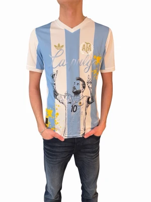Argentina La Pulga Messi tröja - Snygg fotbollströja i ljusblått och vitt med tryck av Messi och texten 'La Pulga' framtill samt 'LEO MESSI' baktill. Tröjan har korta ärmar, V-ringning och är tillverkad i ett lätt och ventilerande material. Perfekt för fotbollsfans!