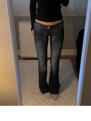 Bootcut jeans i mörkblå denim - Snygga bootcut jeans i mörkblå tvätt med klassiska fickor bak och fram. Lite slitna nere men inget som syns. Låg midja och lätt utsvängda ben ger en tidlös siluett. Perfekta till sneakers eller boots för en avslappnad look. Vill bara bli av med dom så pris kan diskuteras. 