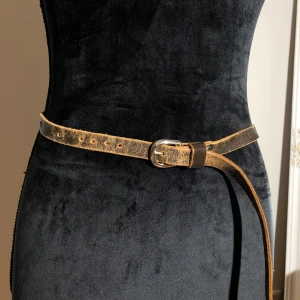 Brunt smalt skärp i skinn - Brunt skärp i läder som är vintage. Längd ca 95cm. Pris: 10kr 