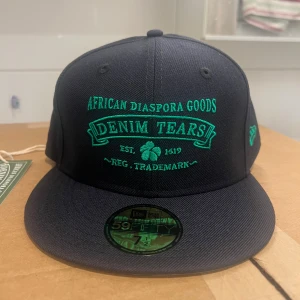 Navy keps Denim Tears x New Era 59FIFTY - Snygg navyblå 59FIFTY keps från Denim Tears och New Era med grön broderad text och detaljer. HELT NY MED TAGS PÅ!! Retail ligger på 1000kr+skatter och tullar från USA. Har kvitto, orderbekräftelse osv!  Size står på bilden