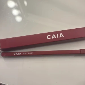 CAIA läppenna Ruby Plum - Läppennan Ruby Plum från CAIA i en djup plommonröd nyans. Pennan har en smal och precis form som gör det enkelt att definiera läppkonturen, fick i julkalendern men kommer ej komma till användning 