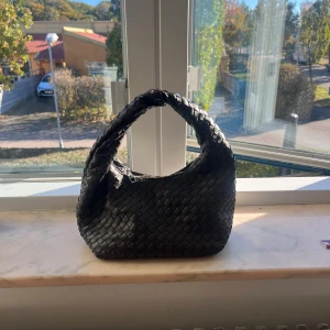 Mörkbrun flätad axelväska från Gina Tricot - Snygg mörkbrun axelväska från Gina Tricot i flätad skinnimitation. Väskan har en rundad form, dragkedja upptill och ett innerfack med extra dragkedja. Perfekt för att lyfta din outfit med en trendig touch. Är i super bra skick 💗