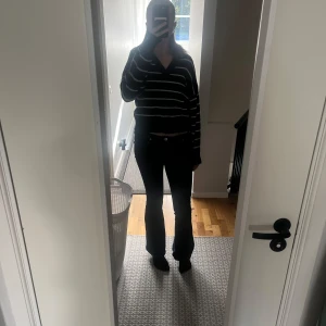 Marinblå randig stickad tröja - Säljer en marinblå stickad tröja med vita ränder och v-ringad hals. Perfekt för dig som gillar en avslappnad och trendig stil.