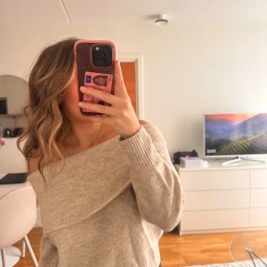 Beige offshoulder stickad tröja - Superfin beige stickad tröja med bred ribbad kant och offshoulder, storlek xs