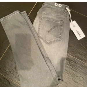 Grå smala jeans från Dondup - Säljer ett par grå jeans från Dondup! De är i bra skick 9/10. Riktigt snygga och sköna, säljer de til ett rikgit bra pris. Vid frågor eller funderingar tveka inte på att höra av dig!