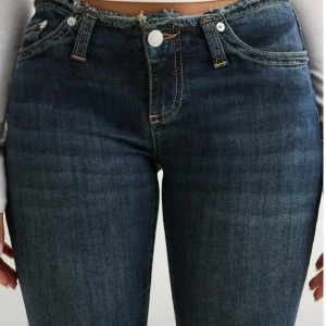No waist jeans från Nelly  - Snygga mörkblå jeans med bootcut passform och låg midja. Jeansen har en rå, fransad kant upptill och klassiska fickor både fram och bak. Materialet är stretchigt denim som sitter skönt och markerar siluetten. Skriv för fler bilder!