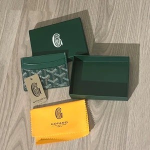 Grön Goyaard plånbok med mönster - Snygg grön plånbok från Goyaard med ikoniskt grafiskt mönster i vitt och grått. Kommer med original ask och gul putsduk. Perfekt för kort och småsaker, stilren och lyxig design som sticker ut.