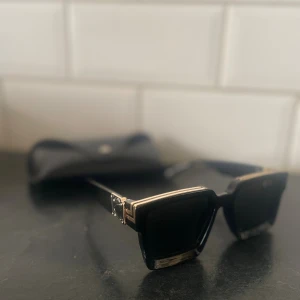 Svarta solglasögon  med guld! - Säljer ett par svarta solglasögon från SHEIN med rektangulär form och coola guldfärgade metalldetaljer på bågarna. Glasögonen har en chunky design och kommer med ett svart fodral. Perfekt för dig som gillar statement-accessoarer.