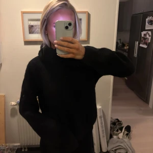 Svart stickad hoodie från GG Luxe - Mysig svart stickad polotröja från GG Luxe med långa ärmar. Tröjan har en oversized passform och ribbade muddar vid ärmsluten. Perfekt för kalla dagar när du vill vara både bekväm och snygg. Hittar tyvärr inte vilket storlek den är i, men passar mig med S, och passar nog mellan XS-M ❣️Tröjan är som ny, inga tecken på användning!