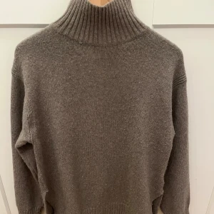 Brun stickad polotröja med slits - Mysig beige polotröja från H&M i storlek XS. Tröjan är stickad med ribbad hög krage. Skulle säga att den är stor i storlek. Den har slits på sidorna. Hör av er vid flera frågor 