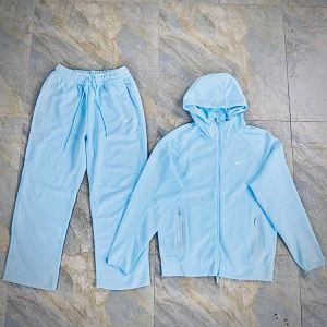 Nike NOCTA ljusblå  - Nike NOCTA hoodie i ljusblått. Snygg minimalistisk design med vita loggor på bröstet och NOCTA-detalj på ärmen. Tillverkad i mjuk bomullsblandning, perfekt för chill dagar eller träning.