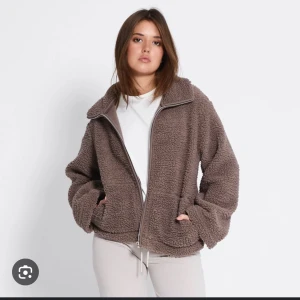 Brun teddyjacka med dragkedja - Mysig brun teddyjacka med hög krage och hel dragkedja framtill. Jackan har två fickor och en loose passform som ger en avslappnad vibe. Perfekt för kyliga dagar när du vill vara både varm och snygg. Jag har M i storlek men passar även S, även slutsåld på lager 157🤎🍂