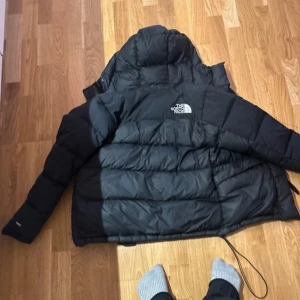 Svart dunjacka från The North Face XS - Säljer en svart dunjacka från The North Face i storlek XS. Jackan har huva med dragsko, två stora fickor framtill och dragkedja. Klassisk pufferstil med quiltade sektioner och logga på bröstet och ryggen. Perfekt för kalla dagar. Tar emot prisförslag. Skriv för betalning kan diskutera pris