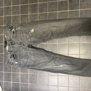 Replay jeans med slitningar  - Säljer ett par grå jeans från Replay med skinny fit och slitna detaljer på låren och knäna. Jeansen har klassisk femficksdesign, dragkedjegylf och tydliga slitningar för en cool, avslappnad look.  Modellen är willbi men sitter exakt som anbass