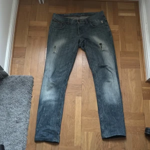 Blå slitna jeans med raka ben - Ett par snygga blå jeans med raka ben. Cool wash på benen och lite hål och slitningar på olika ställen. Var inte rädd alls för att ställa frågor eller be om mer bilder. Skickar direkt. W33 L34