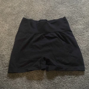 Svarta träningsshorts - Svarta träningsshorts med tight passform och scrunch-detalj bak. Mjukt och stretchigt material som sitter skönt på kroppen, perfekta för gymmet eller löprundan. Klassisk look som funkar till alla sportiga outfits.