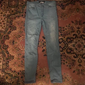 Ljusblå Replay jeans slim fit - Säljer ett par ljusblå jeans från Replay med klassisk femficksdesign och smal passform. Jeansen har normal midja och är tillverkade i mjukt denimtyg med lätt tvättad look. Perfekta för dig som gillar stilrena och bekväma jeans. Midja 36cm längd 100cm (41)