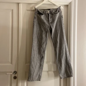 Grå  jeans straight fit - Säljer ett par klassiska grå  jeans med rak passform och normal midja. Jeansen har fem fickor, knappgylf och är tillverkade i slitstarkt bomullsdenim. Perfekt för dig som gillar tidlös stil och vill ha ett par jeans som funkar till allt.