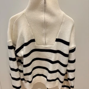 Randig polotröja med dragkedja - Vit/svart randig polotröja med hög ribbad krage och dragkedja jätte mysigt speciellt nu till hösten/vintern.🤍
