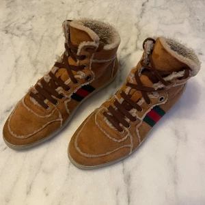 Gucci shearling fur and suede web sneakers  - Säljer nu minna Gucci shearling fur and suede web sneakers. Stl 43,5 (passar runt 43,5 - 44,5). Skick 9-10. Retail runt 9-11.000kr mitt pris 3.899kr. Ett mer luxuöst vall till dig som vill ha något lika bekvämt som UGS men vill ha något av högre klass och stil.