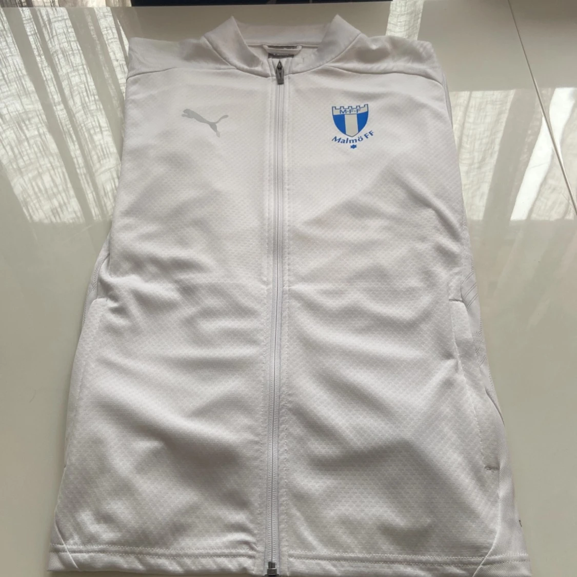 Vit jacka från Puma med Malmö FF-logga