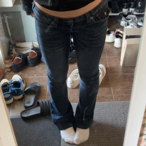 Bootcut Mörkblåa true religions med rhinestones - Jätte snygga true religion jeans med rhinesstones på sidorna. 🙌Många kristaller har gått bort för jag hade för hög temperatur i tvättmaskinen men de är fortfarande snygga🙌. Men annars finns de inga defekter på jeansen alls🥰Jag är 1.63.      Priset kan diskuteras!