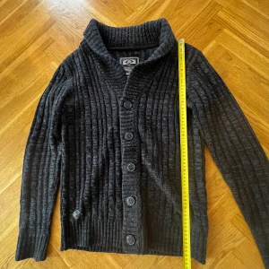 Stickad ull cardigan/kofta - En stickad cardigan i ull den har inga defekter utan att lappen på vånster sidan är synligt andvönd men med den på ser man inte det skick 8/10. Hör av dig vid frågor!
