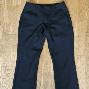 Svarta kostymbyxor från BikBok - Svarta kostymbyxor från BikBok med låg midja i modellen VERA flare. Byxorna har hällor för bälte, snedställda fickor fram och fuskfickor bak. Snygga och moderna och väldigt lite använda. Inga skador. Nypris 499. 