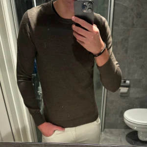 Brun merinoull tröja  - Säljer en stilren brun stickad tröja med rund hals och långa ärmar. Tröjan är i riktigt bra skick och passar perfekt till hösten. Jag är 188cm och den är lite liten på mig. Hör av er vid frågor;)